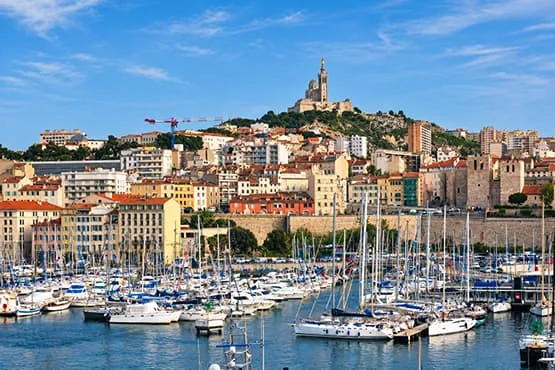 Voiliers dans le Vieux-Port de Marseille, avec Notre-Dame-de-la-Garde en arrière-plan.